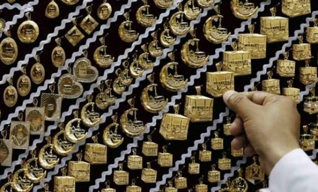 A dealer displays gold pendants at a jewelry shop near the Grand Mosque. (Reuters)